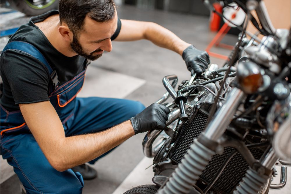 Mechanik v servise opravuje motor motocykla