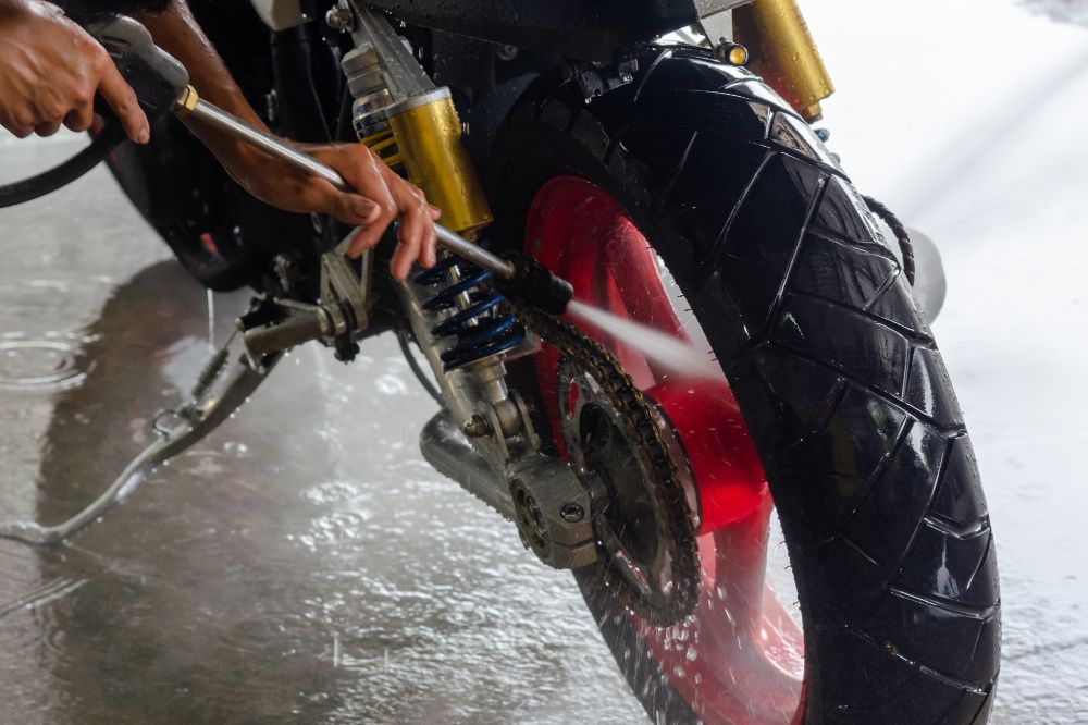 Muž v umyvárni umýva motorku vysokotlakovým čističom