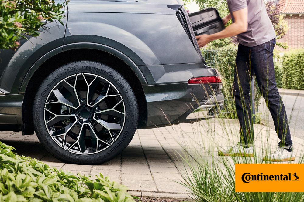 Muž naklad&aacute; batožinu do kufra auta, ktor&eacute; m&aacute; obut&eacute; pneumatiky Continental