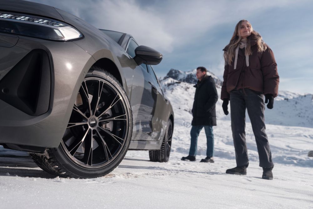 Muž a žena v hor&aacute;ch stoja pri aute s pneumatikami Nokian Tyres Snowproof 3P